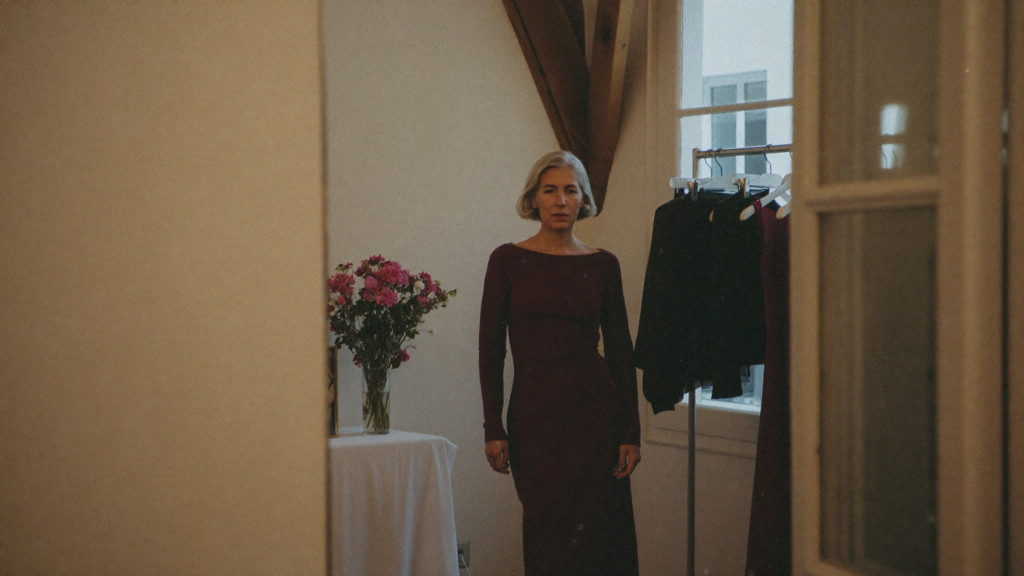 Frau in einem eleganten bodenlangen Festkleid in Bordeaux in einer Boutique